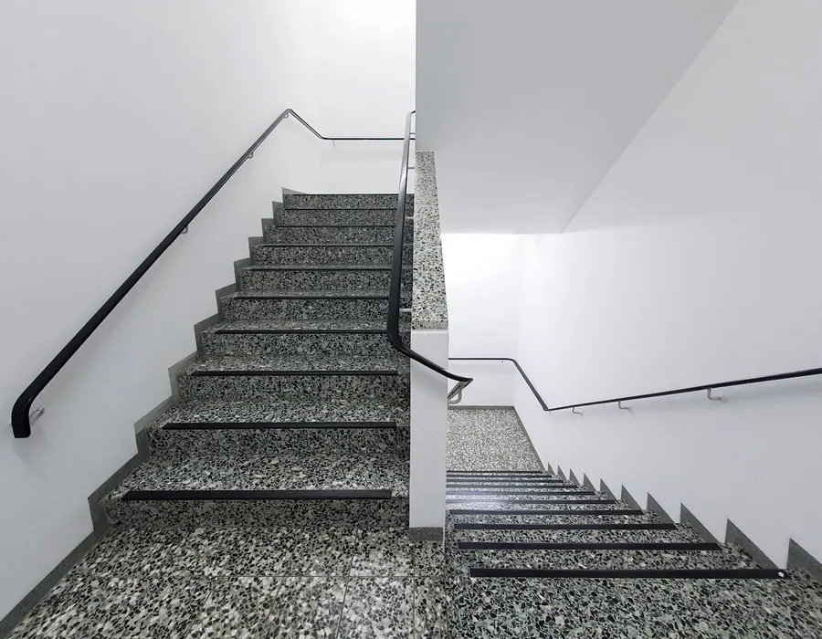 Terrazzo-Treppe mit schlichtem Handlauf in einem Verwaltungsgebäude