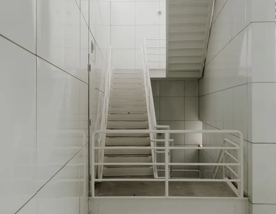 Helles minimalistisches Treppenhaus mit weißem Geländer