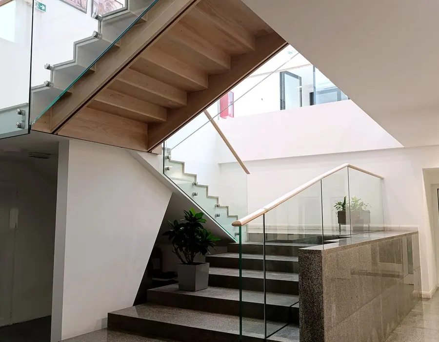 Moderne Innentreppe mit Glasgeländer und Tageslicht